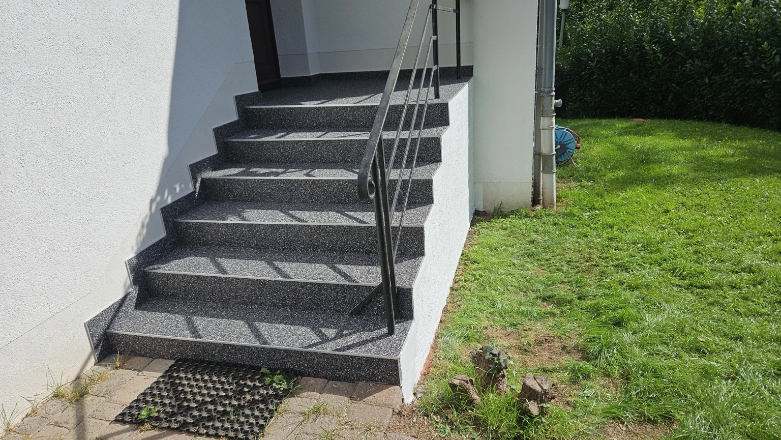 Sanierte Außentreppe mit dunkler gesprenkelter Oberfläche